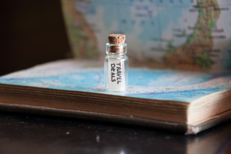 travel deals, inscription "travel deals" in the bottle  and open atlasの写真素材