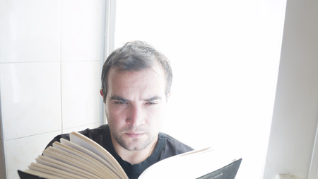 Young man reading a bookの写真素材