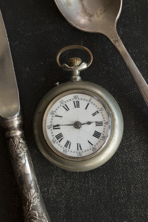 Vintage spoon, knife and pocket watches. Time for dinner.の写真素材