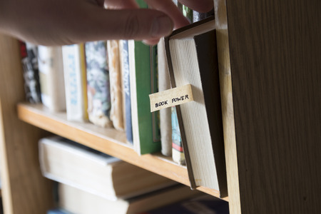 book power concept,  hand selecting book from a bookshelfの写真素材