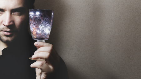 man holding wine glass, colored lights, play of light, focus on glassの写真素材