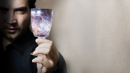 man holding wine glass, colored lights, play of light, focus on glassの写真素材