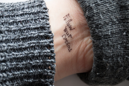 hand with tattoo "follow your dreams"の写真素材