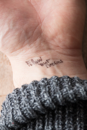 hand with tattoo "follow your dreams"の写真素材