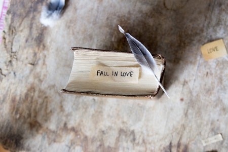 Fall in love. label and book on a wooden table.