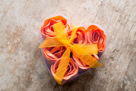 roses on March 8 in a box in the shape of heart on the wooden background.の写真素材