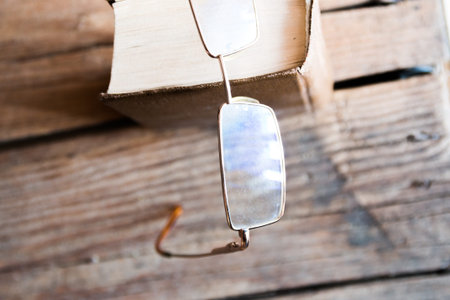 glasses and  book  on an old wooden table
