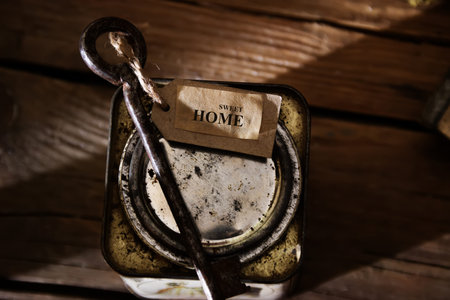 Home Sweet Home. Label and key on wooden table, vintage, toned photo.