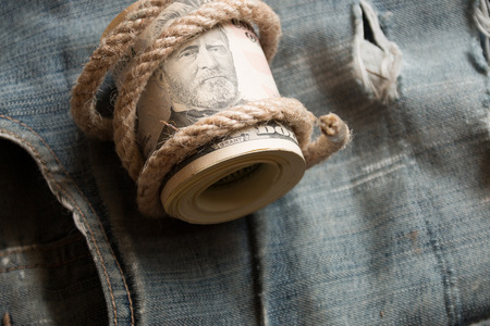 Dollars  lying on old jeans. A roll of fifties.の写真素材