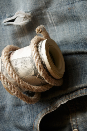 Dollars  lying on old jeans. A roll of fifties.の写真素材