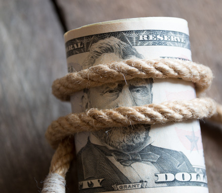 American Fifty Dollar Bills rolled up and rope on a wooden tableの写真素材