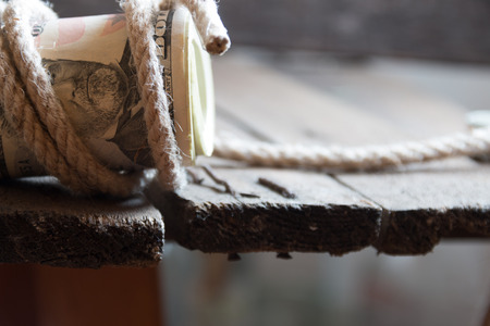 American Fifty Dollar Bills rolled up and rope on a wooden tableの写真素材