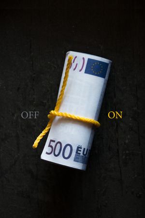 Roll of money switching on on a dark tableの写真素材