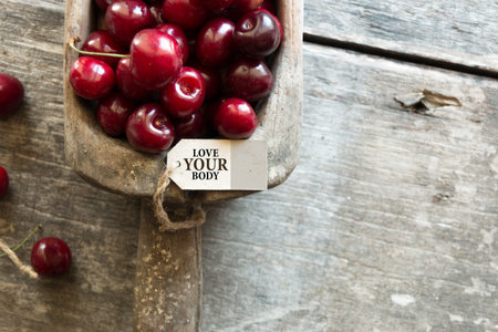 Ripe cherries and an inscription on a wooden table.