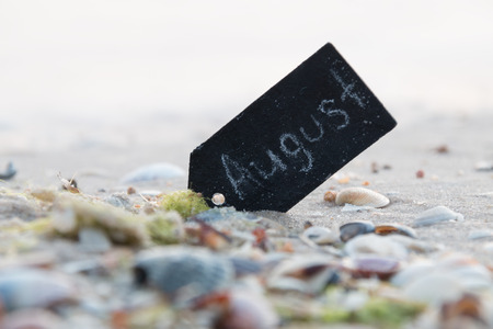 August Travel concept. Sign with the word august on the beach.の写真素材