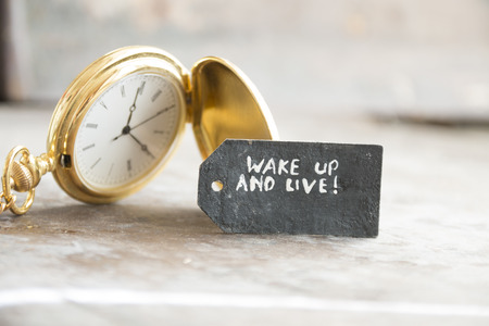 "wake up and live"  inscription on the label and gold pocket watchの写真素材