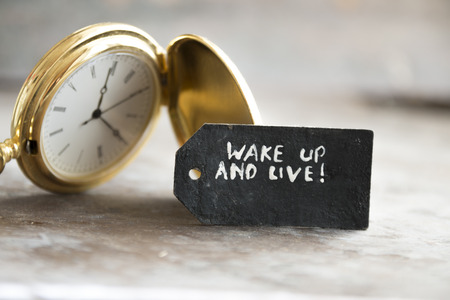 "wake up and live"  inscription on the label and gold pocket watchの写真素材