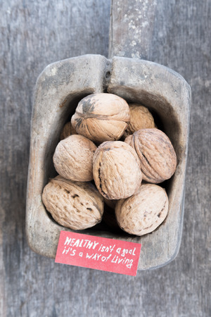Healthy isn't a goal. it's a way of living - inscription on the label and and walnuts. Healthy lifestyle concept.の写真素材