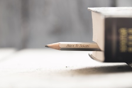 Back to school concept. A pencil and a book on the table, back to school inscription in pencil. , Space for text.の写真素材