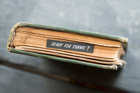 Ready for travel - Text and old book on black table.