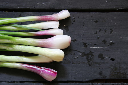 Spring onion on wooden background. Top view. Natural light.の写真素材