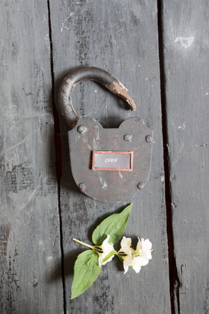 Open sign and old padlock on the table