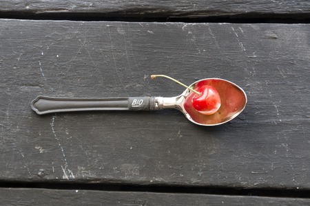 Bio food concept, spoon with a cherry and an inscriptionの写真素材