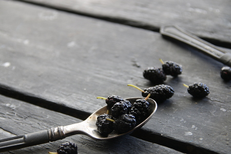 Ripe mulberries on an old black tableの写真素材