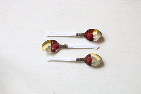 Healthy food idea, spoon with lemon and raspberries a white table.の写真素材