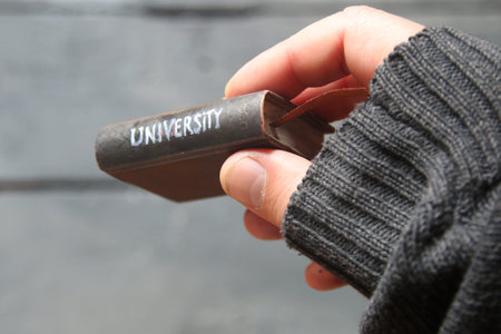 Book with the inscription University. Soft focus