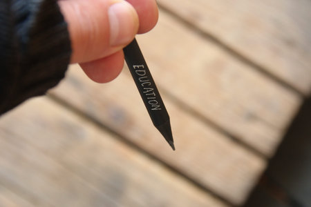 Education idea, hand holding a black pencil with inscription.の写真素材