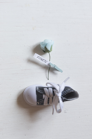 Fitness concept. Rose with text one shoe on a white table.の写真素材
