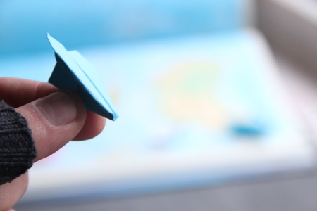 flight idea use for summer holiday vacation traveling, hand holding a paper airplaneの写真素材