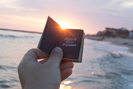 Dream Discover Travel idea - hand with a book and textの写真素材