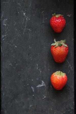 Vegan background, three strawberries on the table,の写真素材