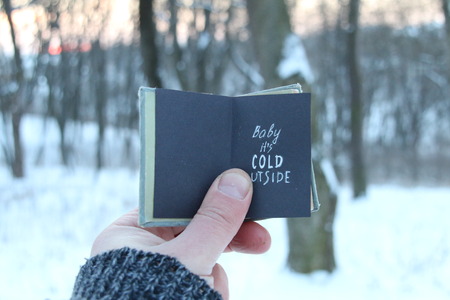 Baby its cold outside. Winter holiday lettering on the book.の写真素材