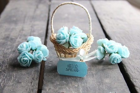 Hello spring tag and flowers in a small basket. Composition on the old table.の写真素材