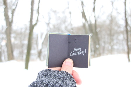 Merry Christmas, man holding a book with the inscriptionの写真素材