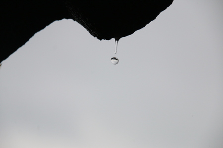 Rain drops falling from old roofの写真素材