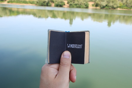 wanderlust, traveler holding a book with textの写真素材