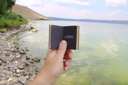 journey, traveler holding a book with textの写真素材