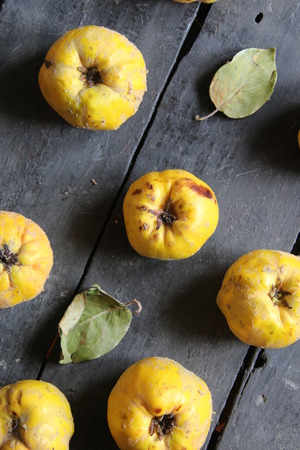 Quince on an old wooden table. Vintage style.の写真素材