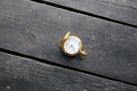 Vintage pocket watch lying on a vintage surfaceの写真素材