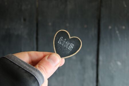 Hand holds heart with an inscription like.の写真素材