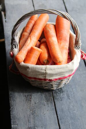 Carrot in the basket on wooden vintage backgroundの写真素材