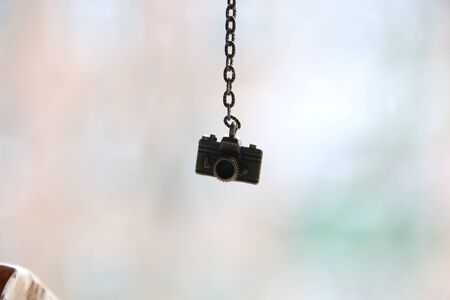 Photographer. Photo album. Travel  or traveler concept. A small bronze photo camera on a chain.の写真素材