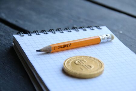 E-Business concept, gold coin and pencil with the inscription. Vintage style.の写真素材
