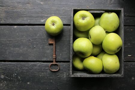 Ripe green apples box on wooden table. Top view with space for your text. Vintage style.の写真素材