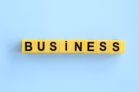 business concept, inscription of yellow cubes on a blue backgroundの写真素材