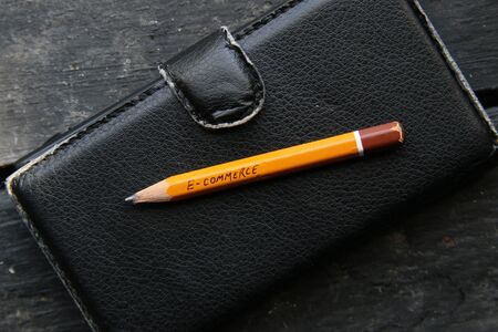 e-commerce concept, pencil and smartphone on an old vintage tableの写真素材